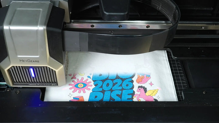 HeyGears G1X printing a full-color design directly onto white fabric in a DTG apparel printing workflow.